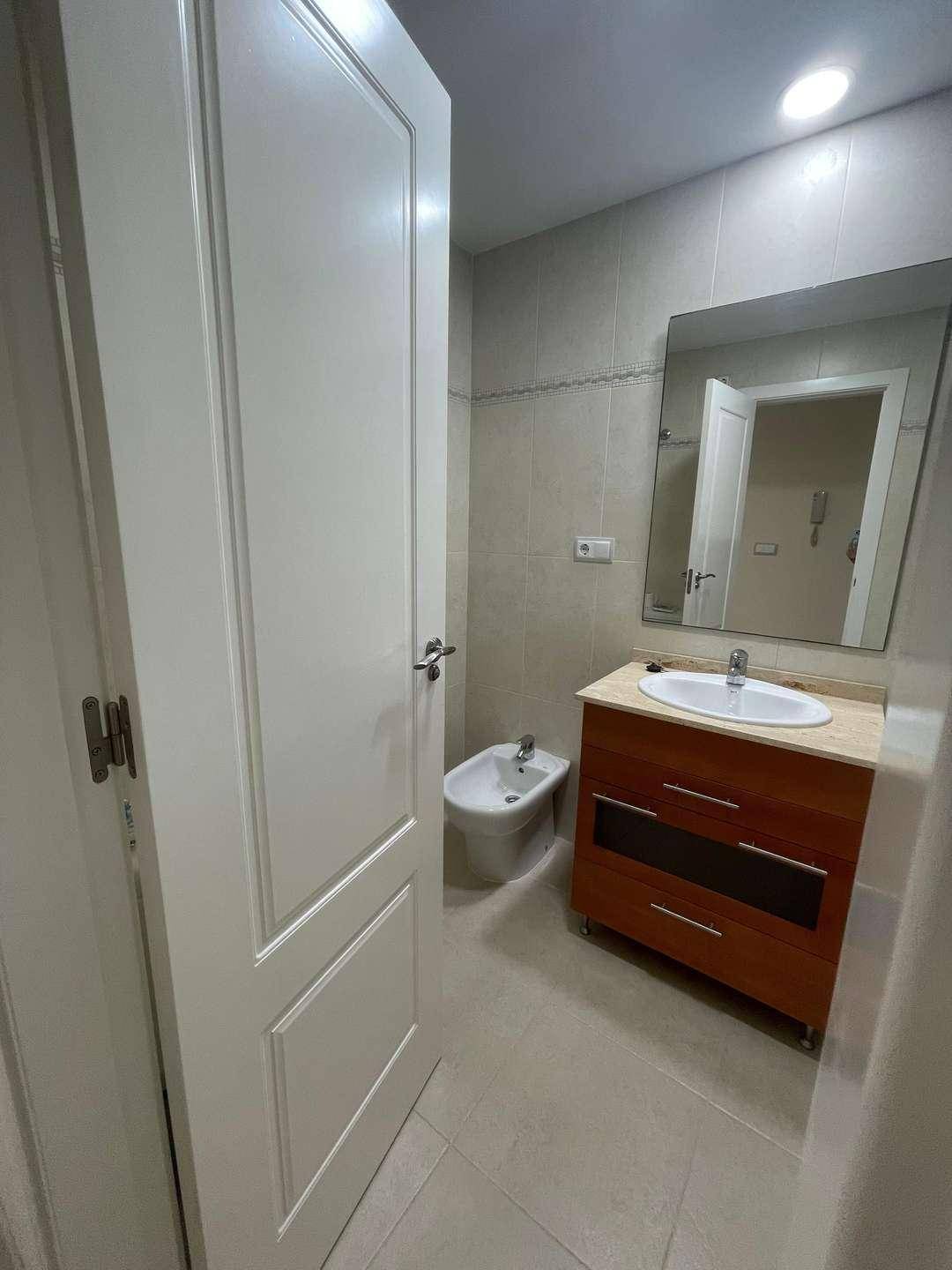 Badezimmer mit Einzelwaschbecken, Bidet und Fliesen an Wänden und Boden.