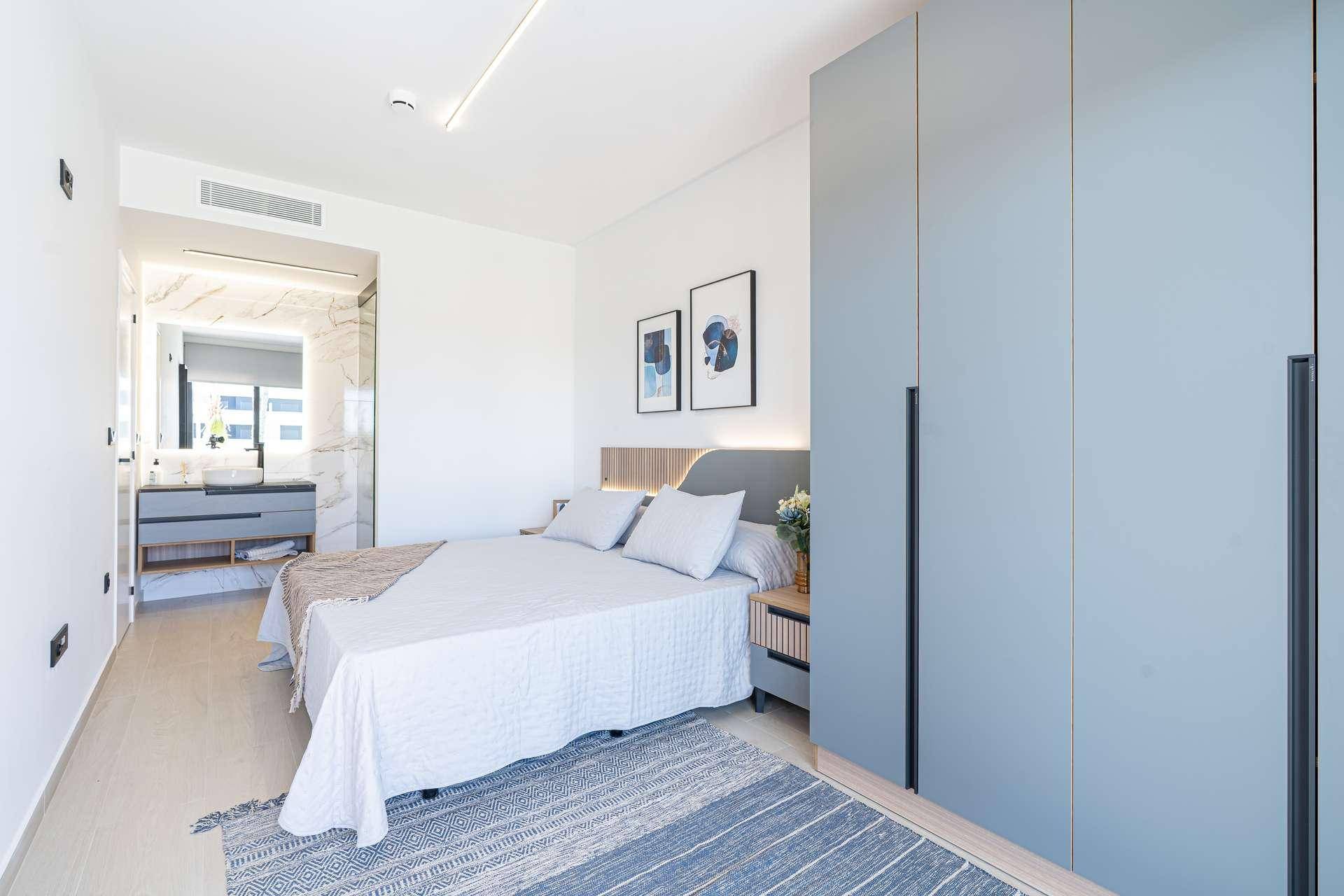 Helles Schlafzimmer mit modernem Design, Einbauschrank und direktem Zugang zum Badezimmer.