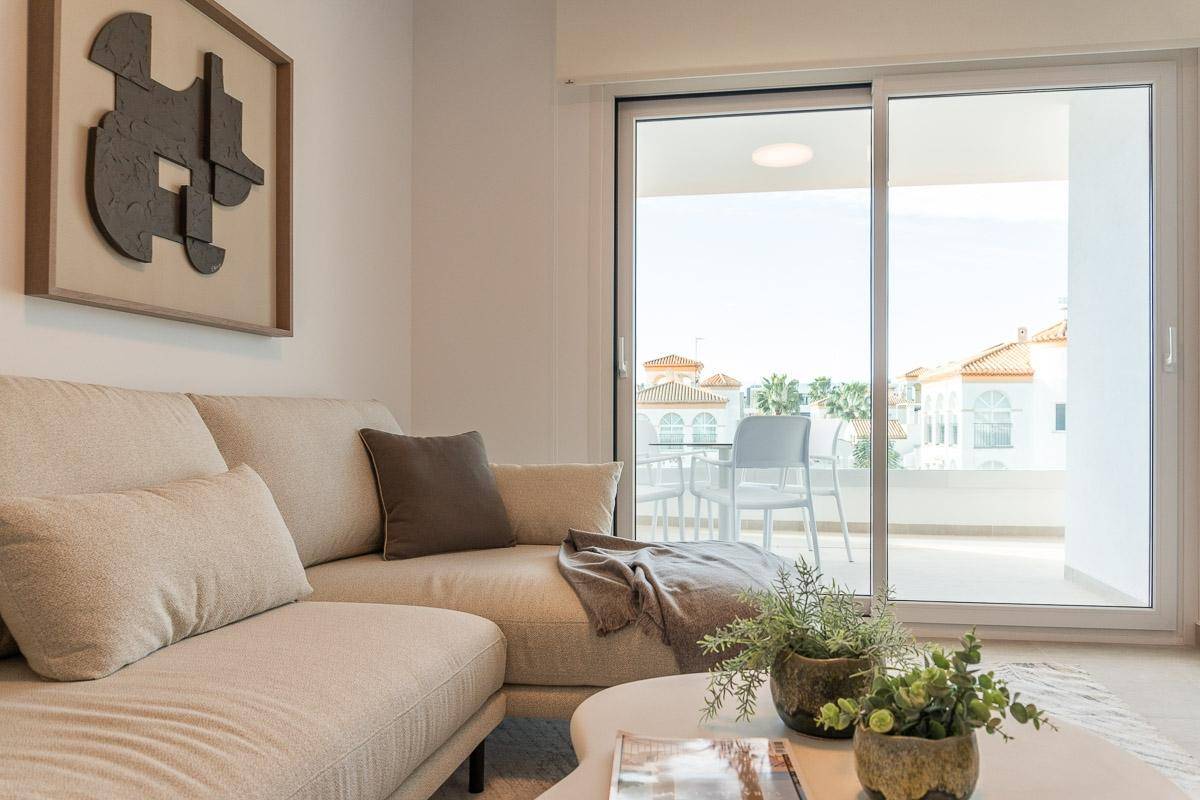Gemütliches Sofa im Wohnzimmer mit Blick durch große Schiebetüren auf den Außenbereich.