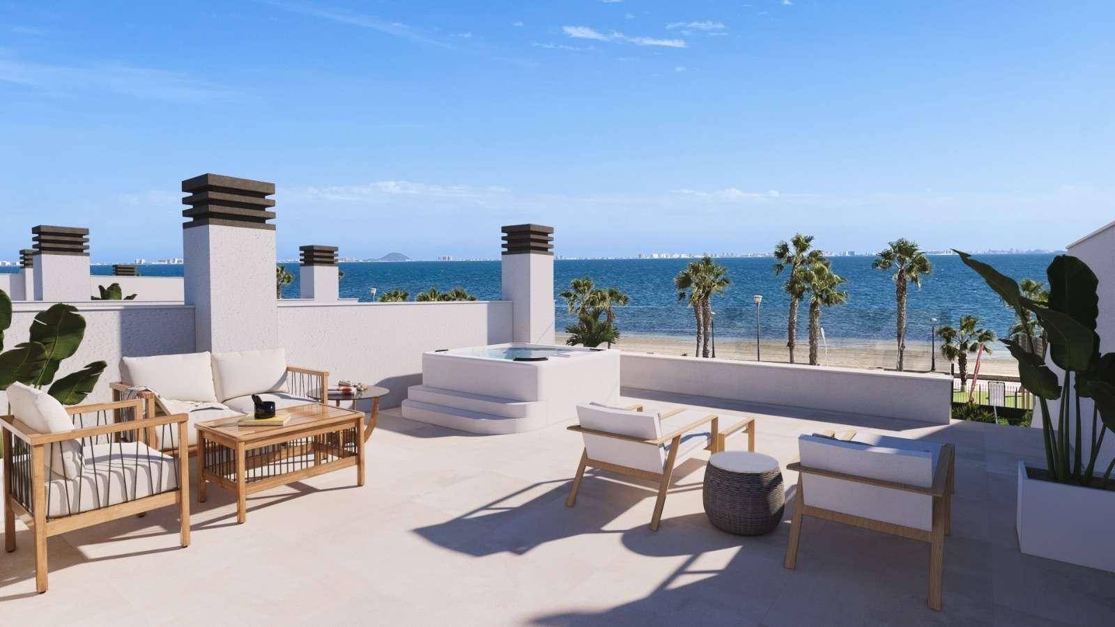 Entspannende Dachterrasse mit Whirlpool, Holzmöbeln und weitem Blick auf das Meer und die Küste.