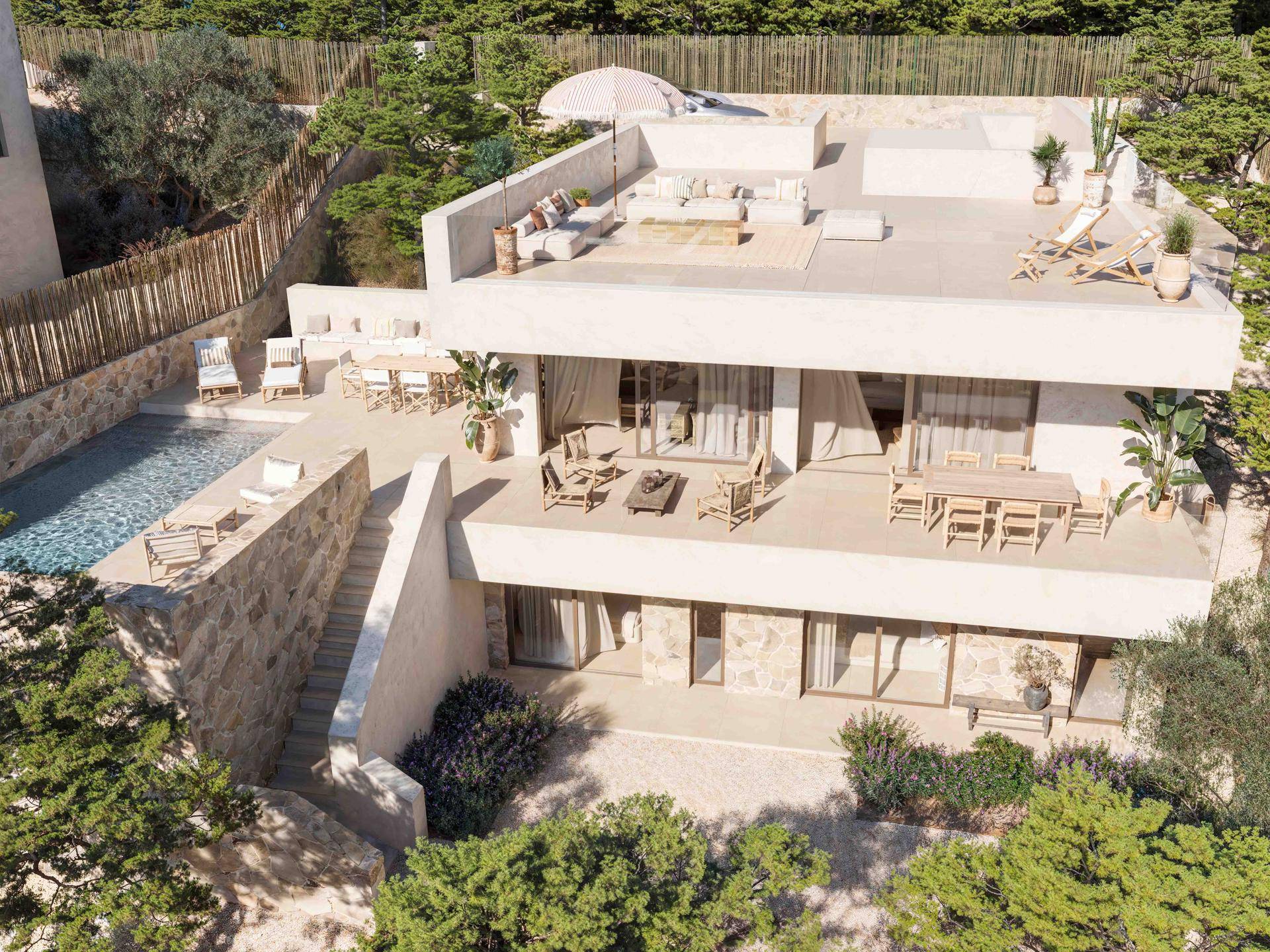 Vogelperspektive der modernen Villa mit mehreren Terrassen, einem Pool und üppiger mediterraner Bepflanzung.