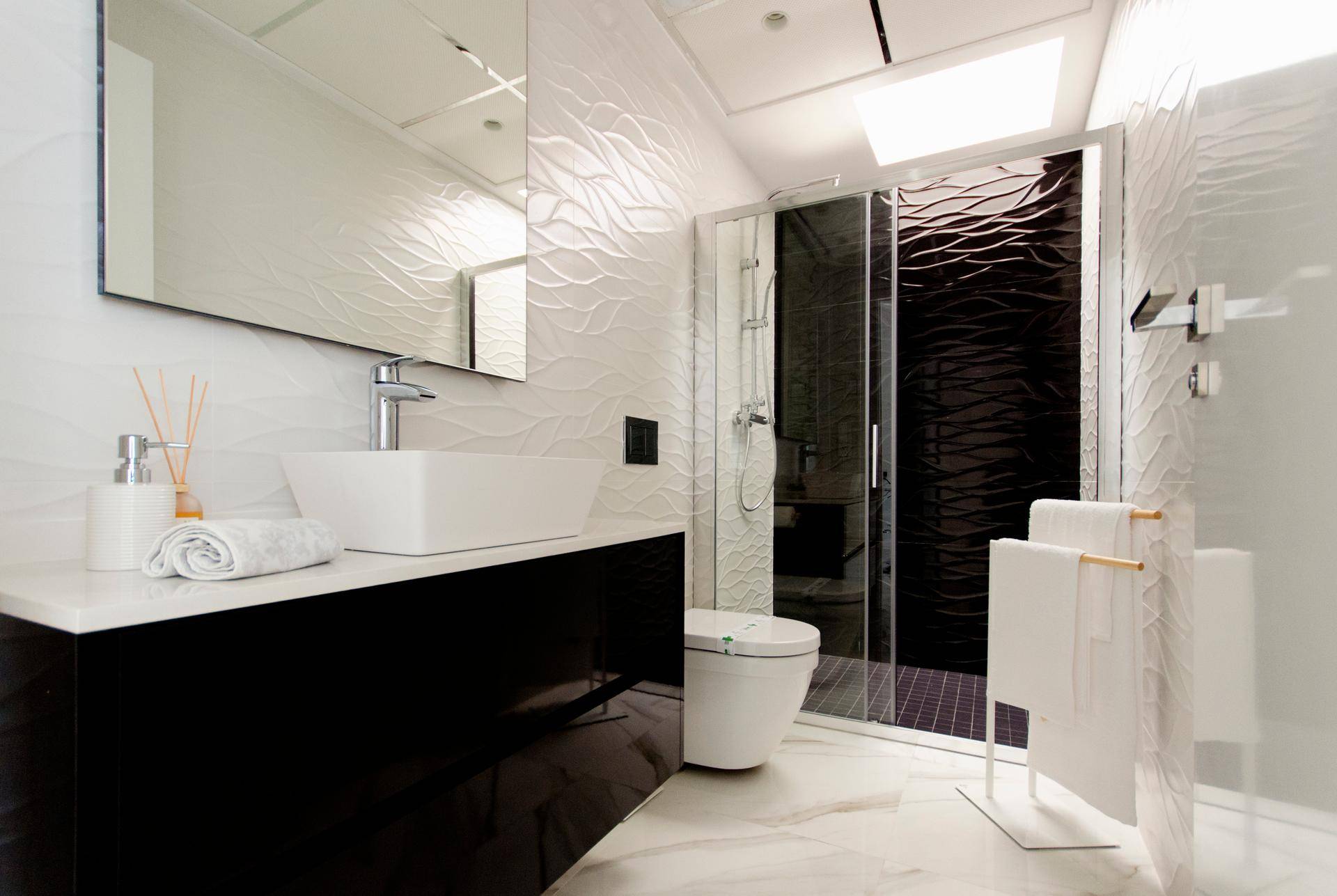 Modernes Badezimmer mit stilvollem Waschtisch, begehbarer Dusche und strukturierten Wandfliesen.