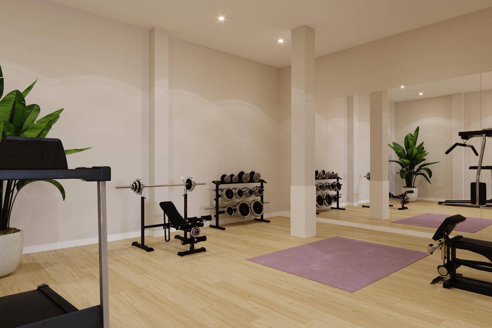 Gut ausgestatteter Fitnessraum mit Hanteln, Laufband und großem Spiegel für das Training.