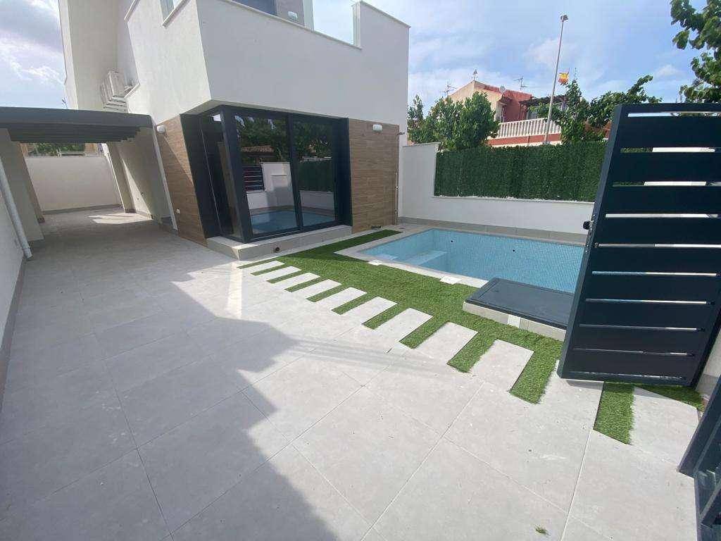 Eingangsbereich einer modernen Villa mit privatem Pool und gefliester Auffahrt.