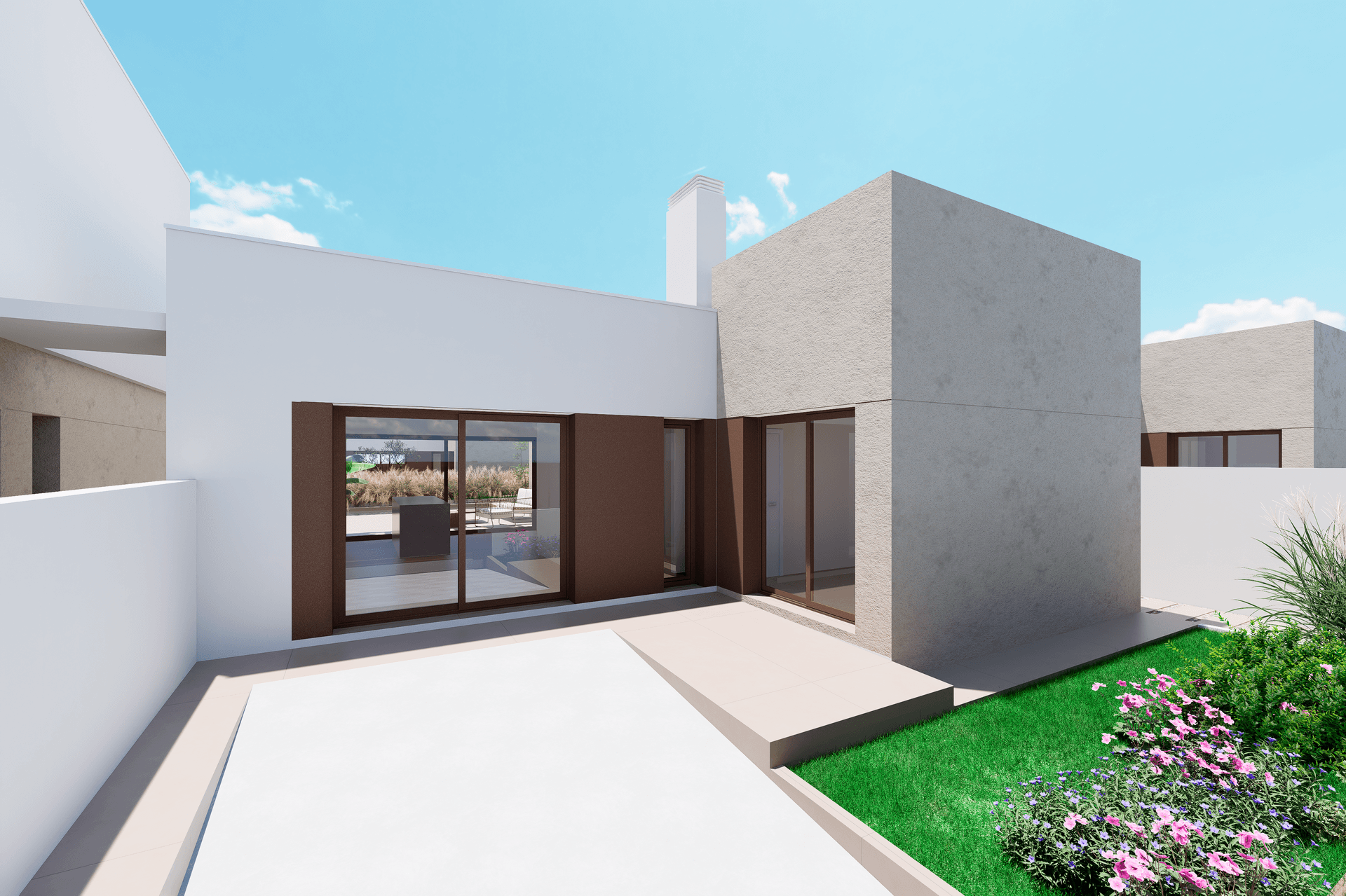 Rückseite einer modernen Villa mit kleiner Rasenfläche und blühenden Blumenbeeten.