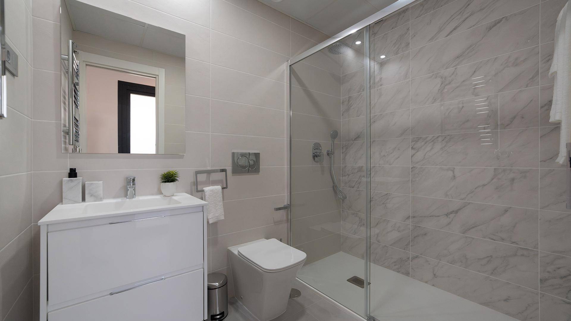 Modernes Badezimmer mit begehbarer Dusche, Waschtisch und Wand-WC.