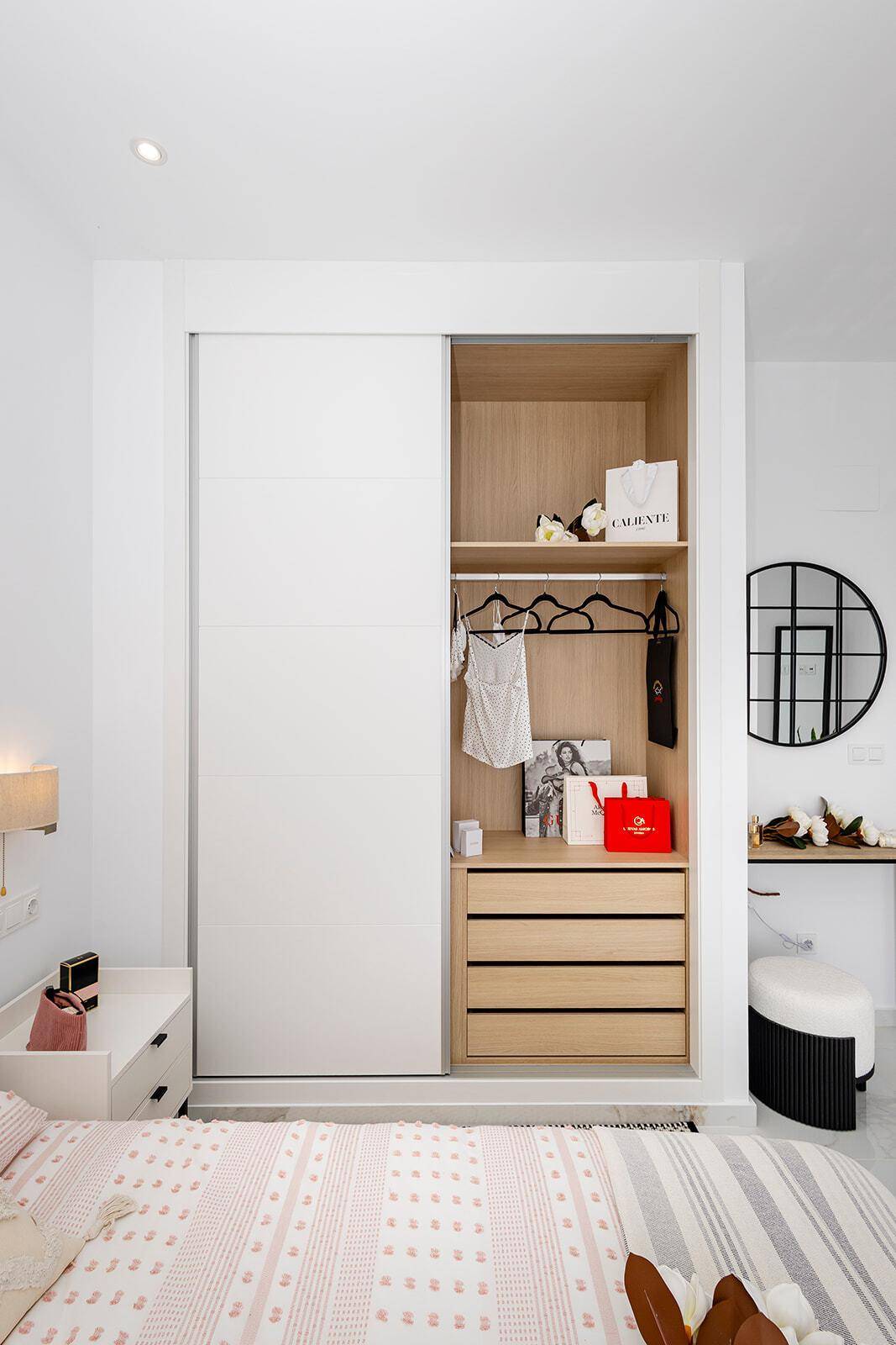 Detailansicht eines modernen Einbauschranks mit Schiebetüren und Holzregalen.