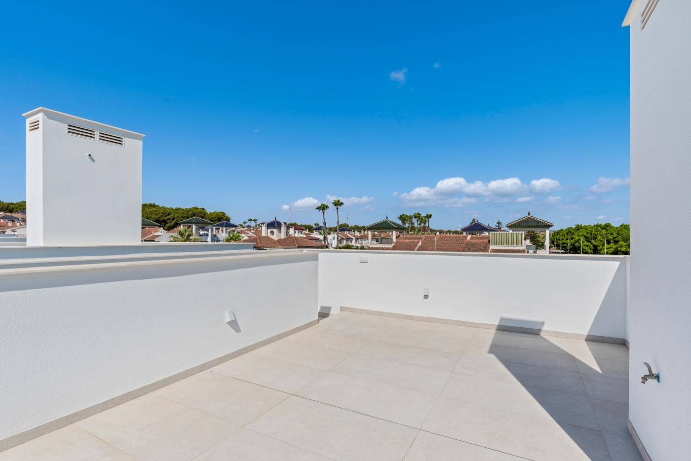 Helle Dachterrasse mit weitem Blick auf die Umgebung und Palmen.