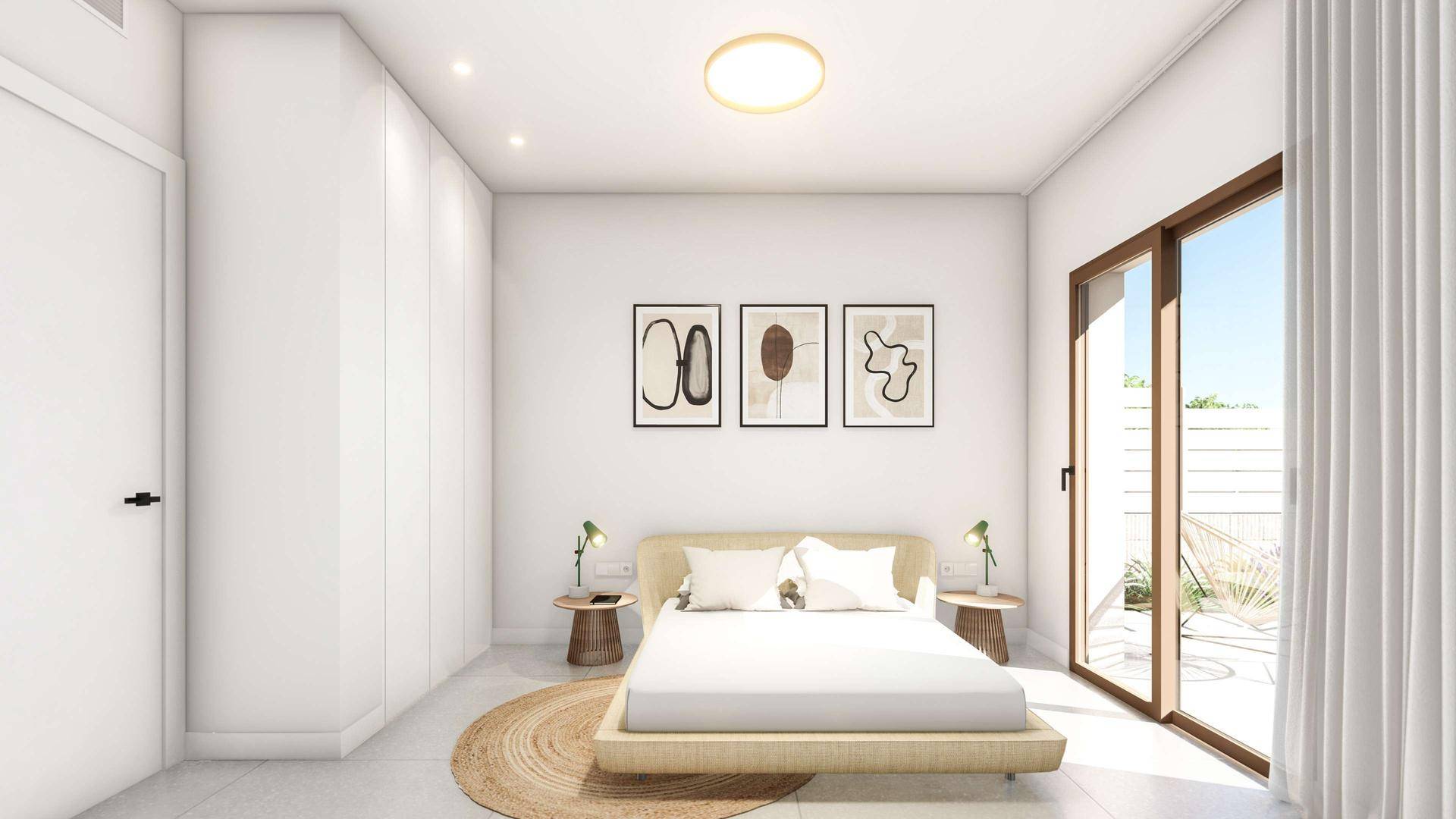 Helles Schlafzimmer mit modernen Einbauschränken und Zugang zu einem Außenbereich.