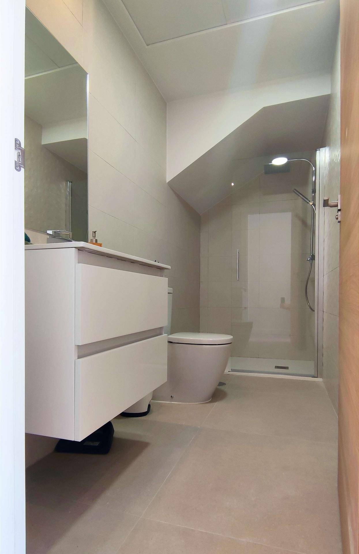Modernes Badezimmer mit begehbarer Dusche, wandhängendem WC und Waschtisch.