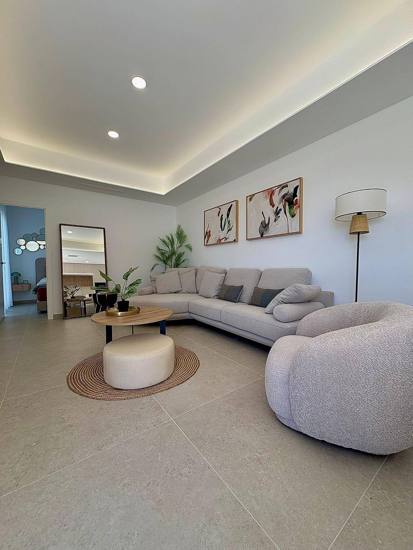 Geräumiges Wohnzimmer mit beigem Ecksofa, modernem Couchtisch und dezenter Beleuchtung.