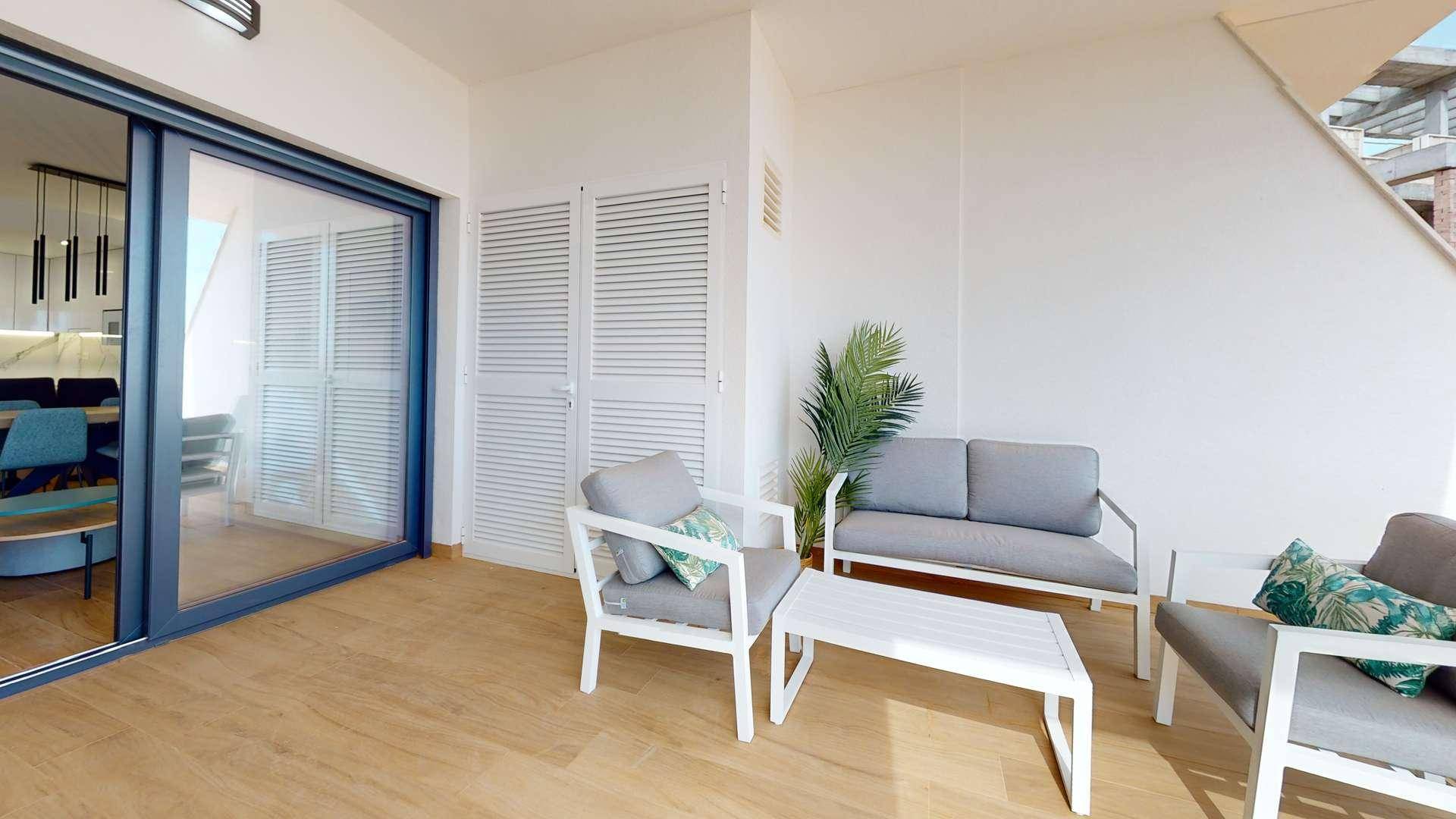 Gemütlicher Balkon mit Holzfußboden, bequemen Sitzmöbeln und Zugang zum Innenbereich.