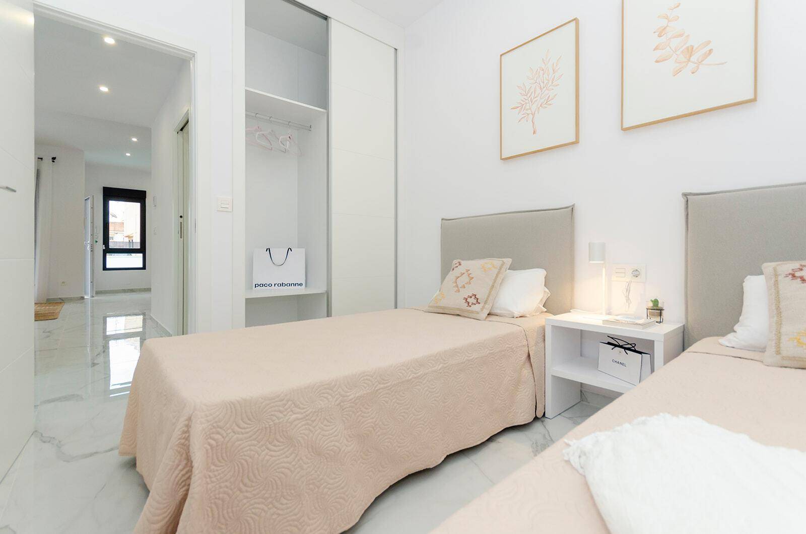 Freundliches Schlafzimmer mit zwei Einzelbetten, modernem Dekor und hellem Fliesenboden.