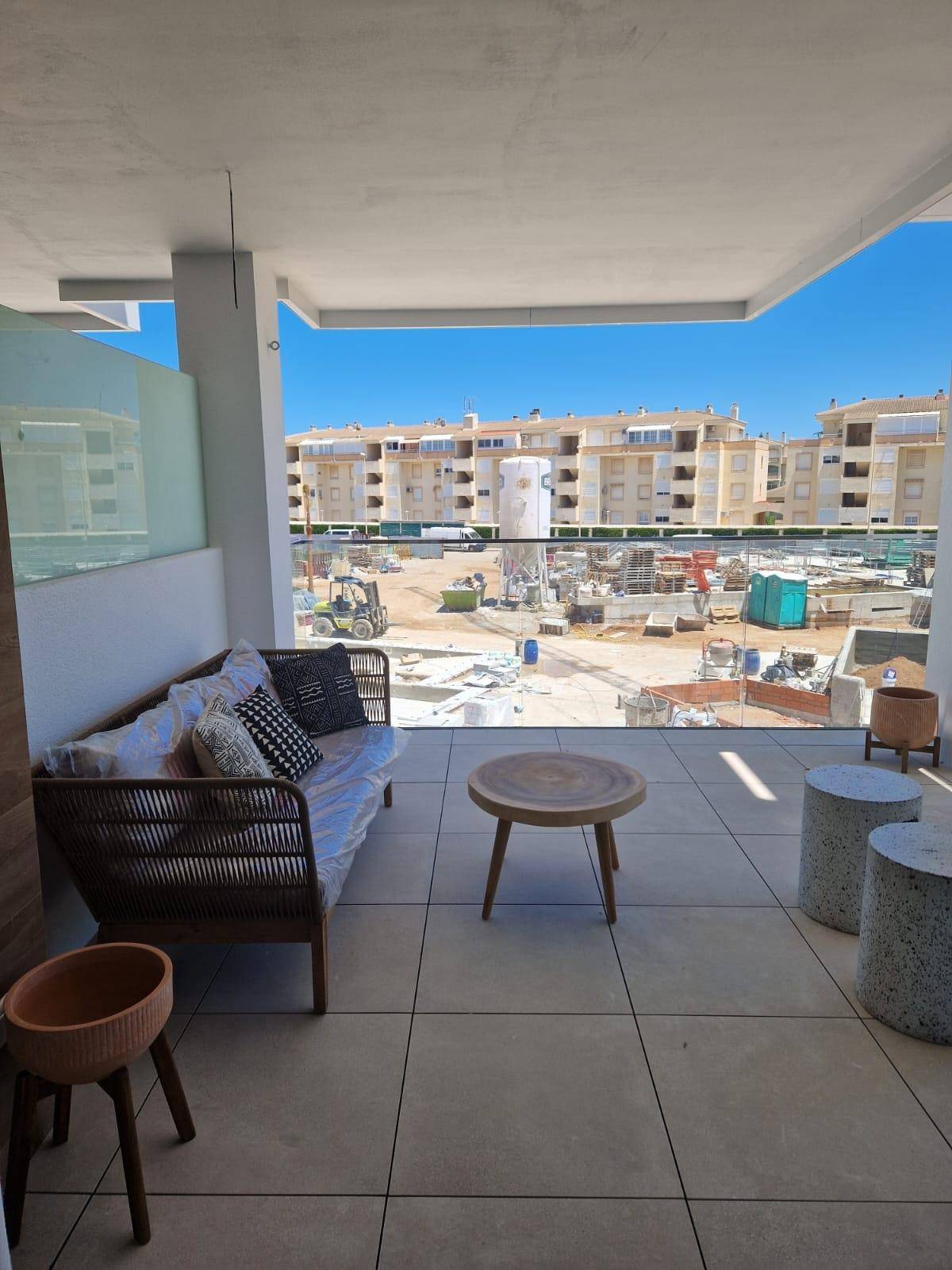 Möblierter Balkon mit moderner Sitzgruppe und Blick auf die umliegende Baustelle.