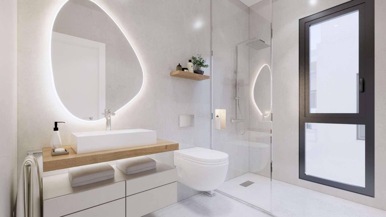 Modernes Badezimmer mit begehbarer Dusche, wandhängendem WC und stilvollem beleuchtetem Spiegel.