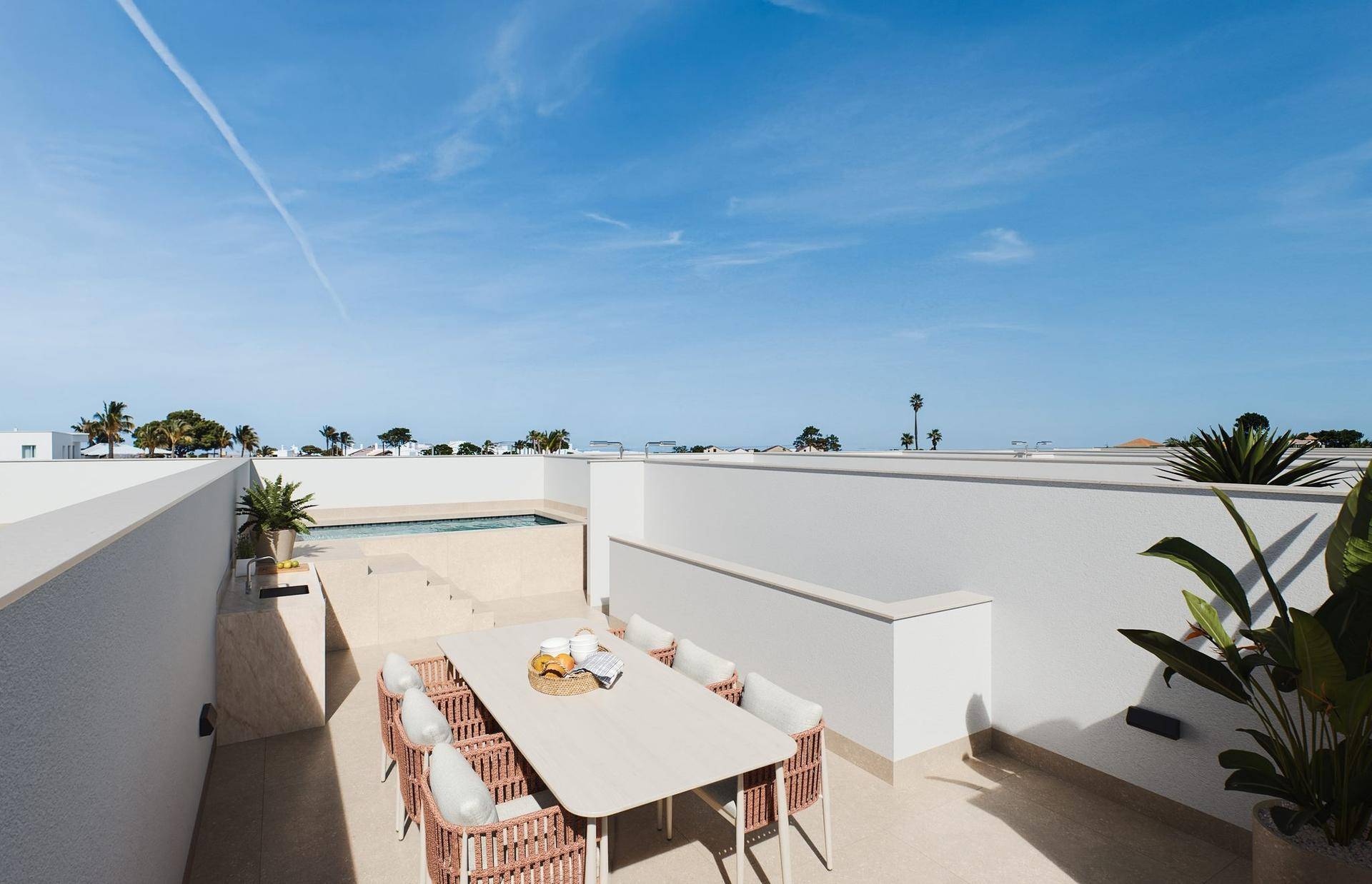 Geräumige Dachterrasse mit Essbereich im Freien und Blick auf den Poolbereich.