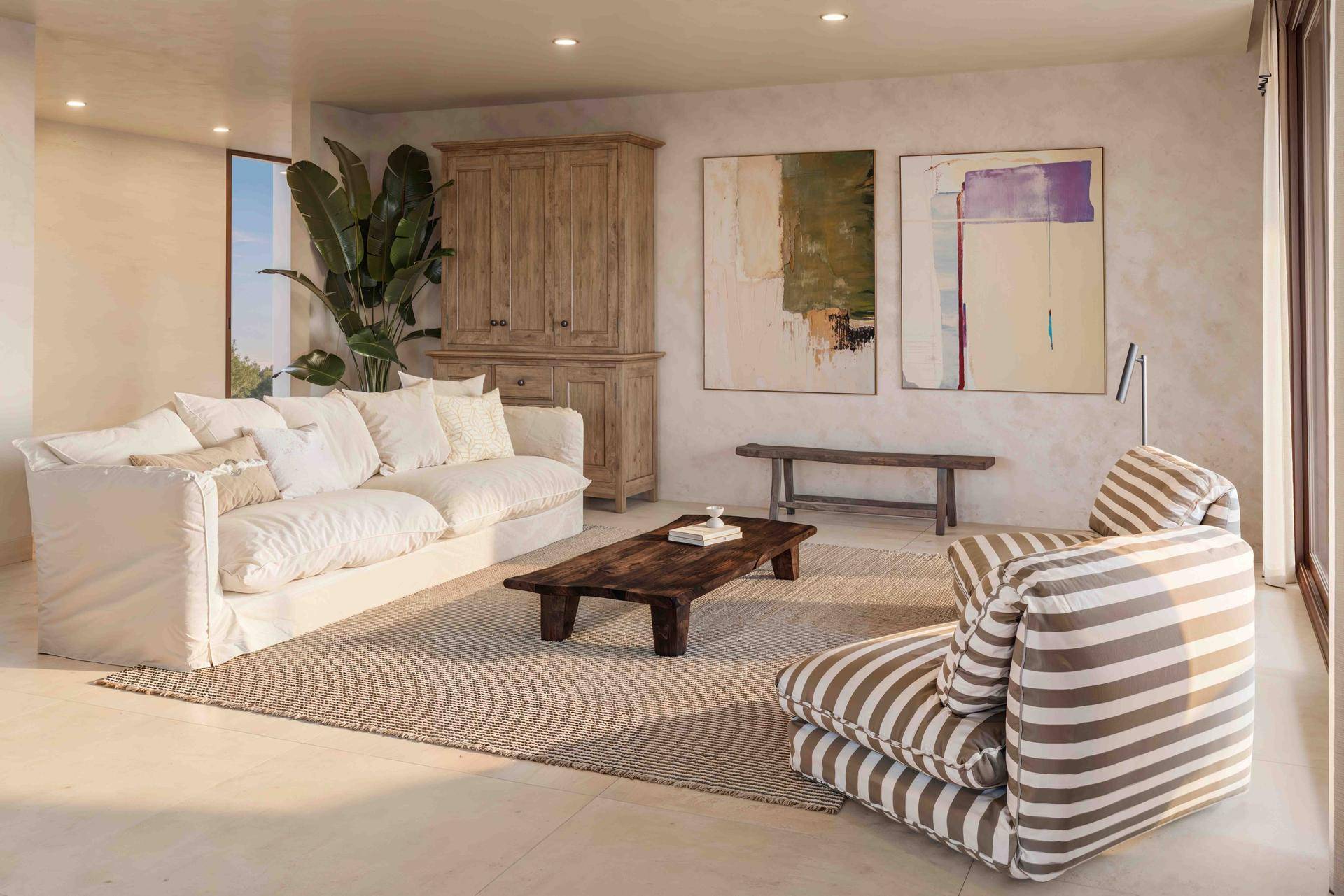 Geräumiges Wohnzimmer mit bequemen Sofas, Holztisch und Kunstwerken an den hellen Wänden.