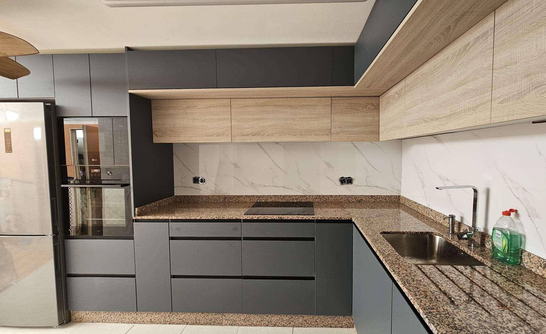 Moderne Küche mit grauen Schränken, Holzakzenten und Granitarbeitsplatten.
