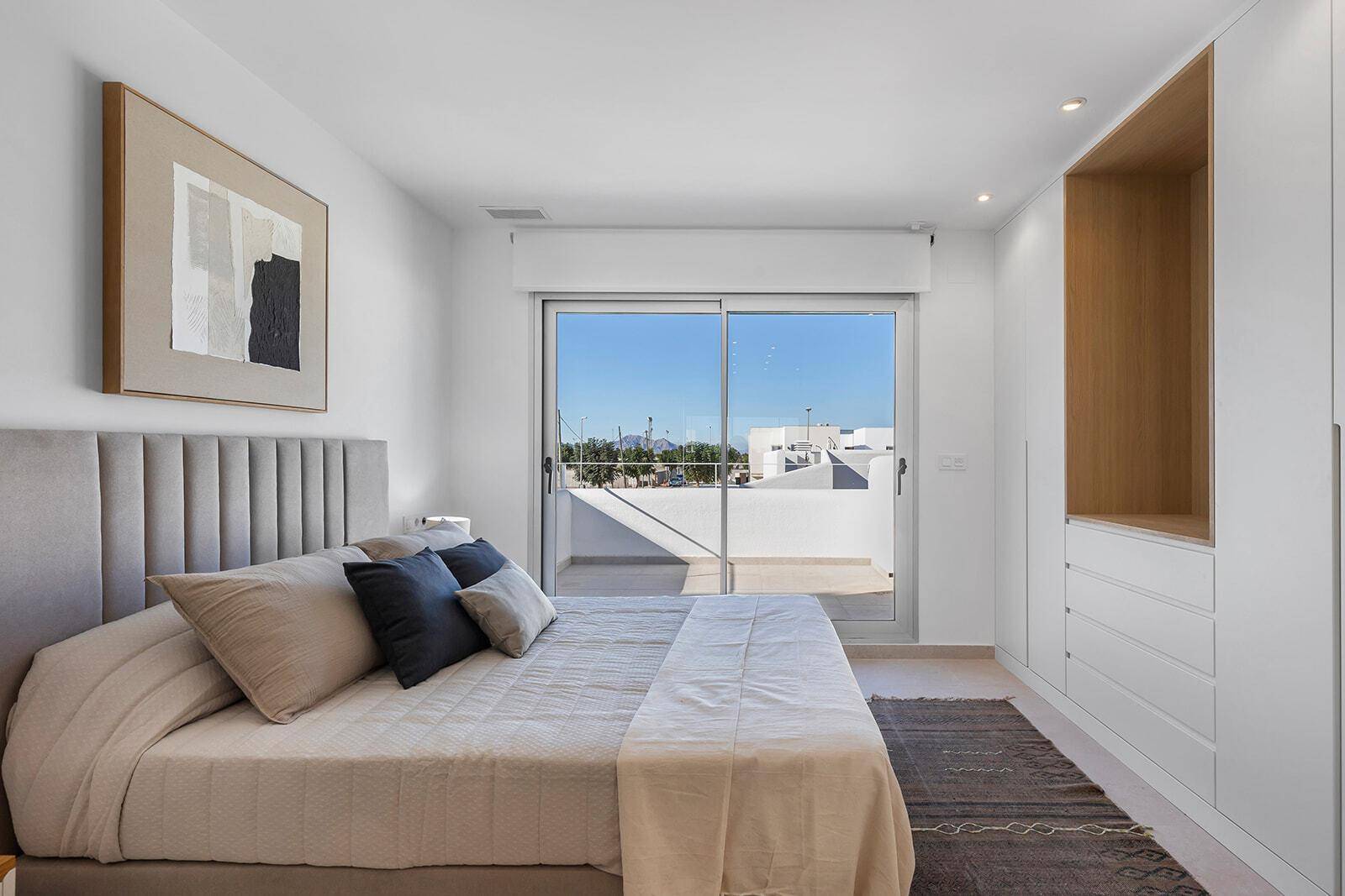 Schlafzimmer mit großem Schiebefenster, das viel Licht hereinlässt und Zugang zur Terrasse bietet.