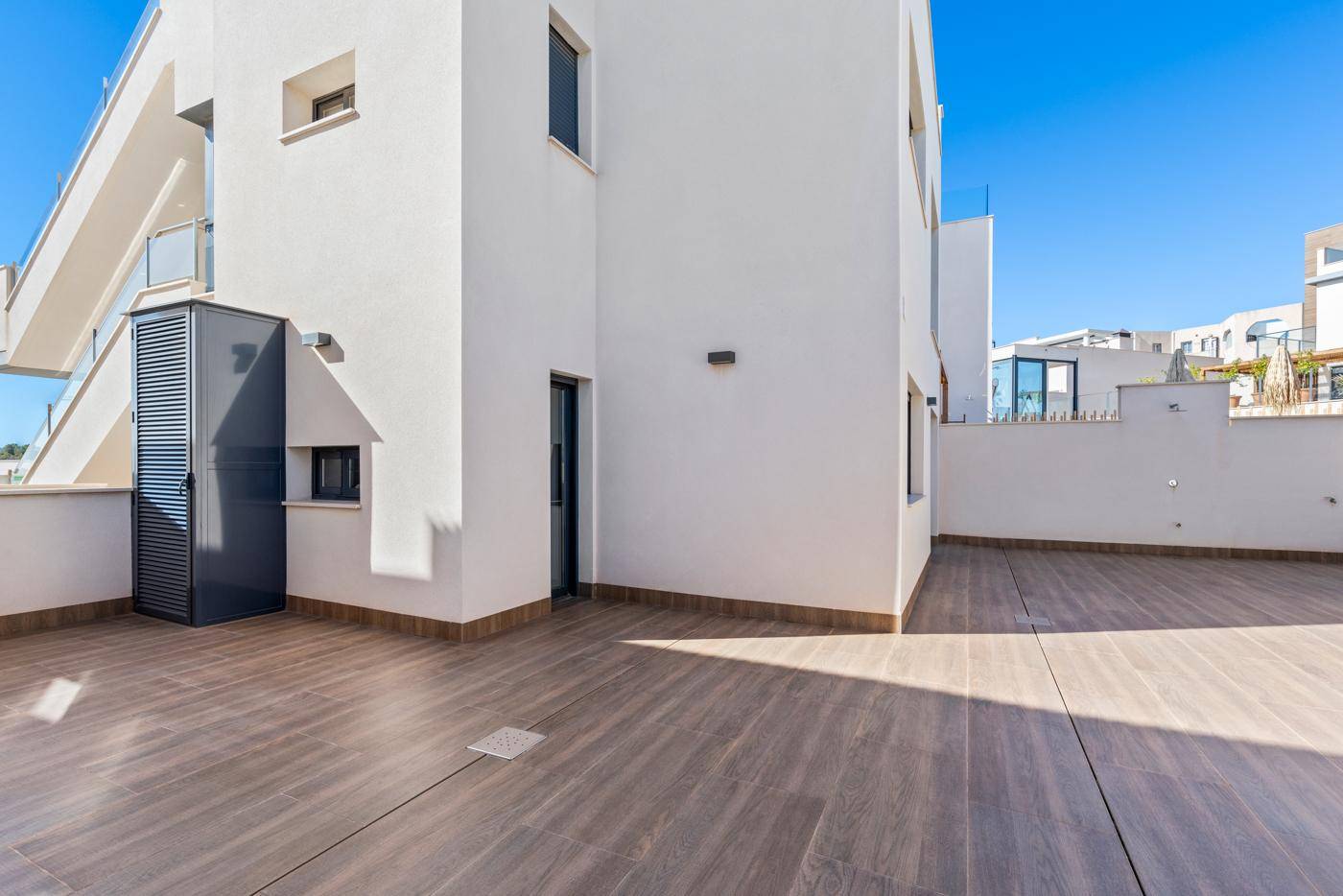 Große, geflieste Terrasse mit viel Platz und einem modernen Schrank im Freien.