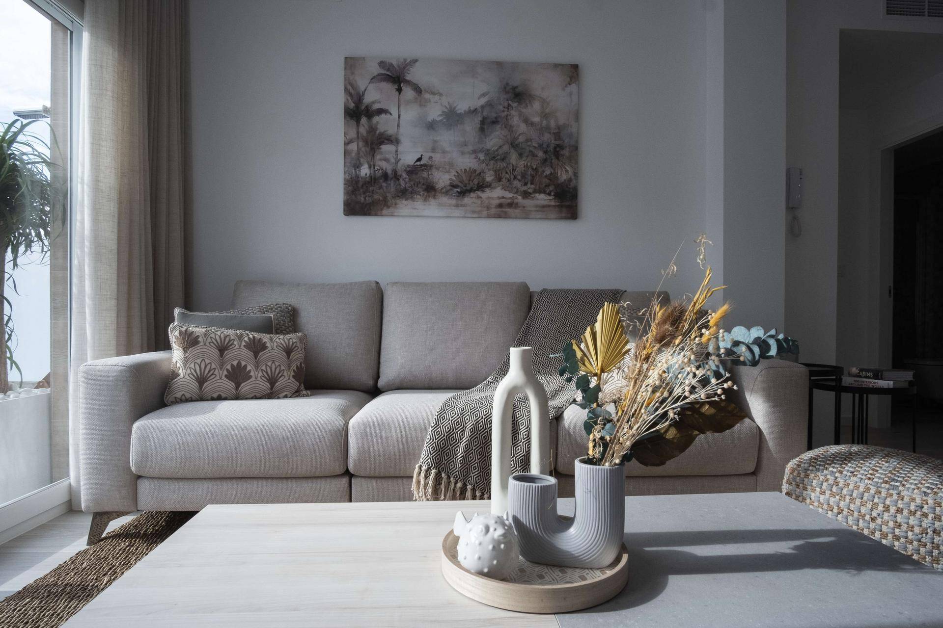 Gemütlicher Wohnbereich mit hellem Sofa, Couchtisch und dekorativen Elementen.