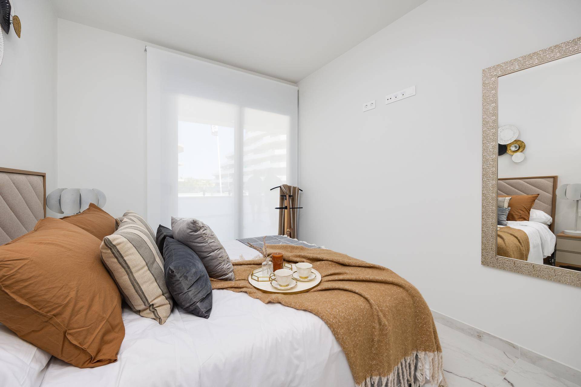 Helles Schlafzimmer mit bequemen Kissen, Marmorboden und großem Fenster.