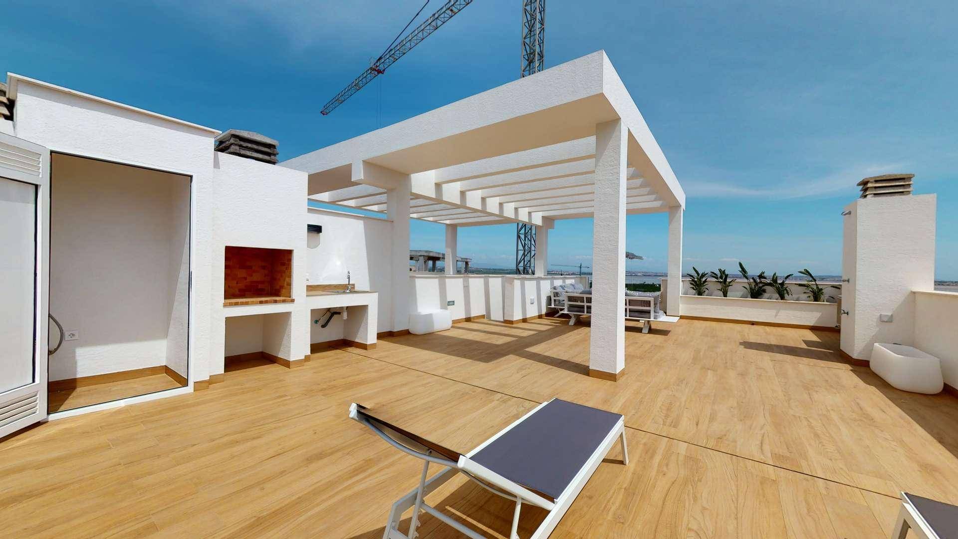 Helle Dachterrasse mit Holzfußboden, Pergola, Sonnenliege und integriertem Grillbereich.