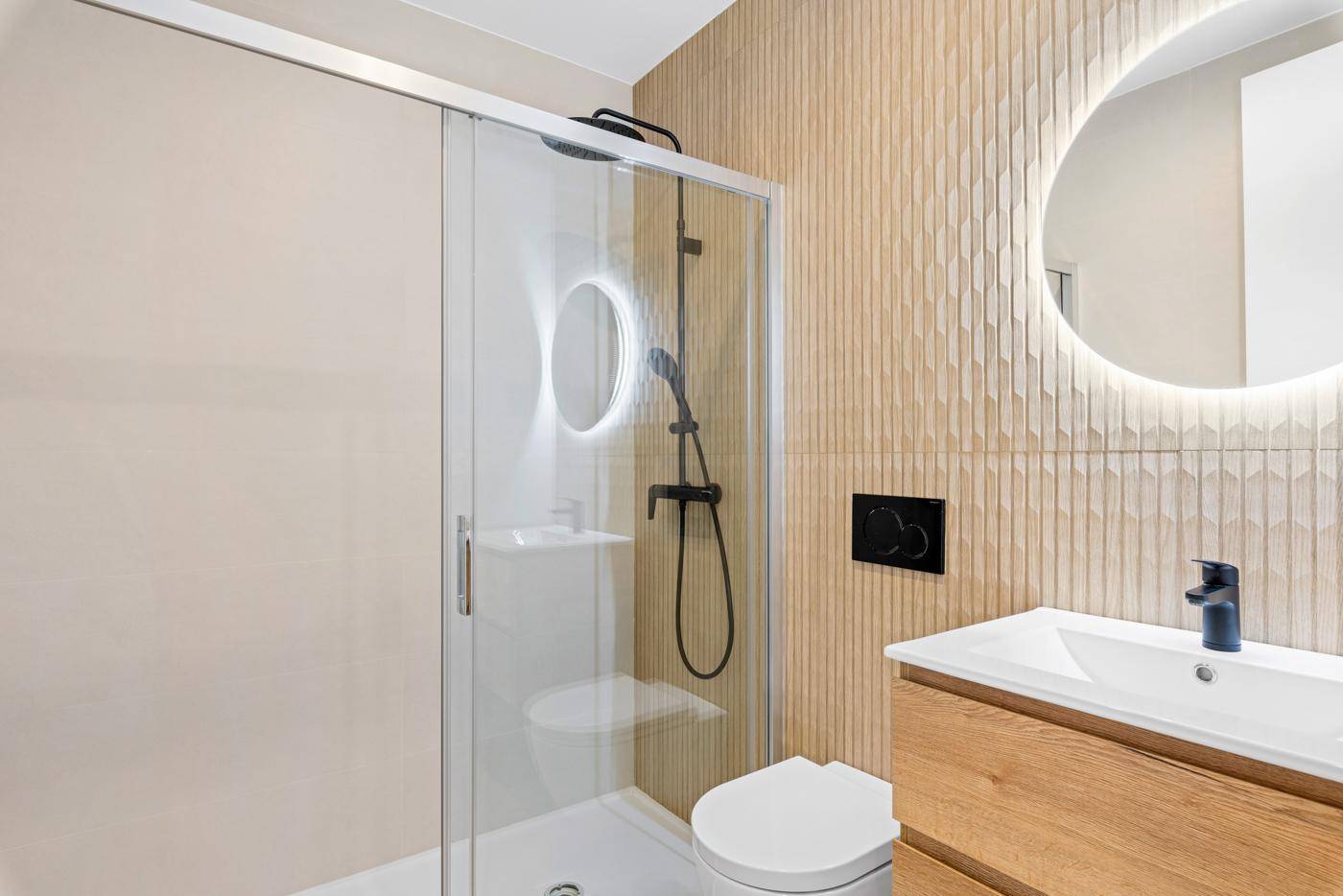 Modernes Badezimmer mit begehbarer Dusche, Holzwaschtisch und beleuchtetem Spiegel.