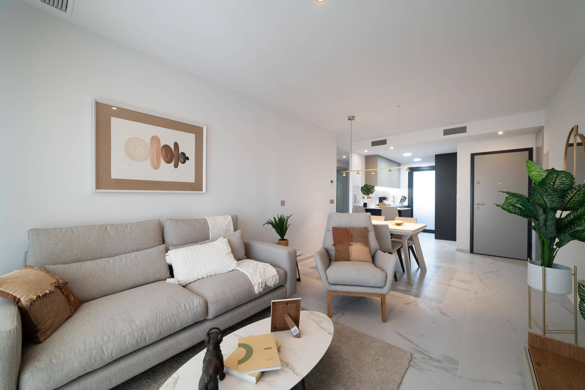 Heller offener Wohn- und Essbereich mit modernem Sofa und stilvoller Dekoration.