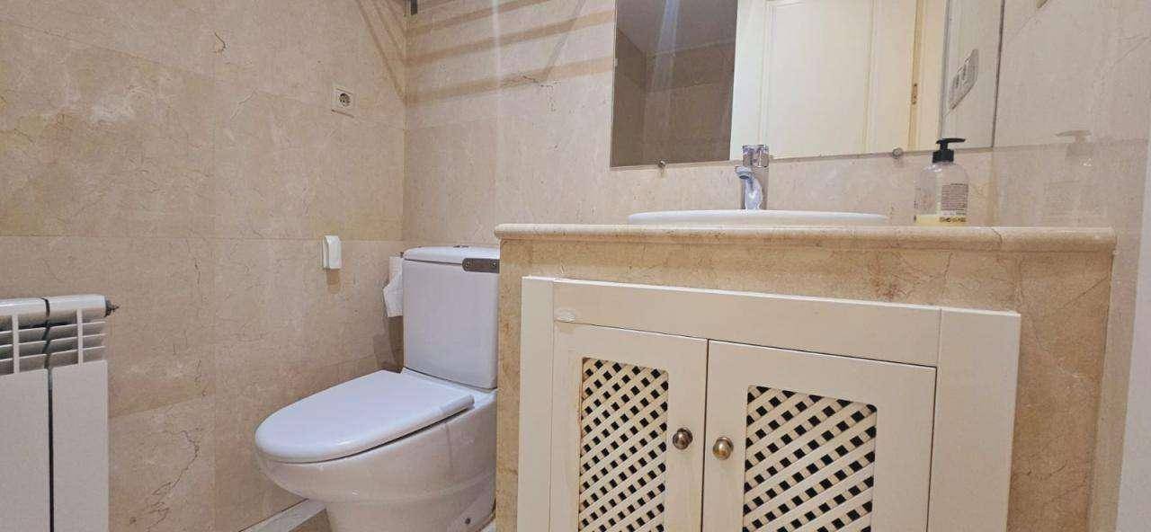 Kleines WC mit Waschtisch, Spiegel und Heizkörper, komplett gefliest.