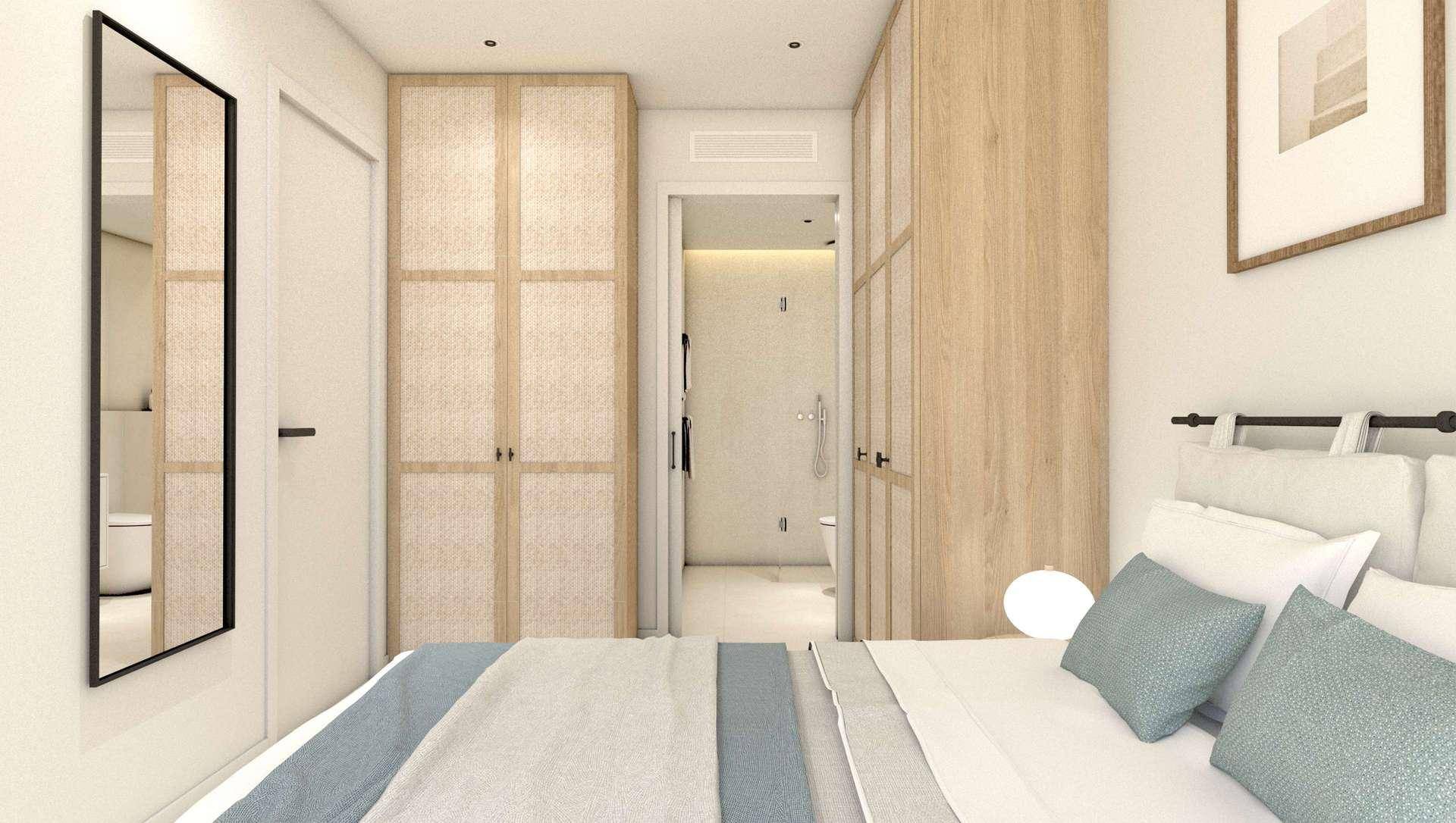 Schlafzimmer mit Doppelbett, Einbauschränken und direktem Zugang zum Badezimmer.