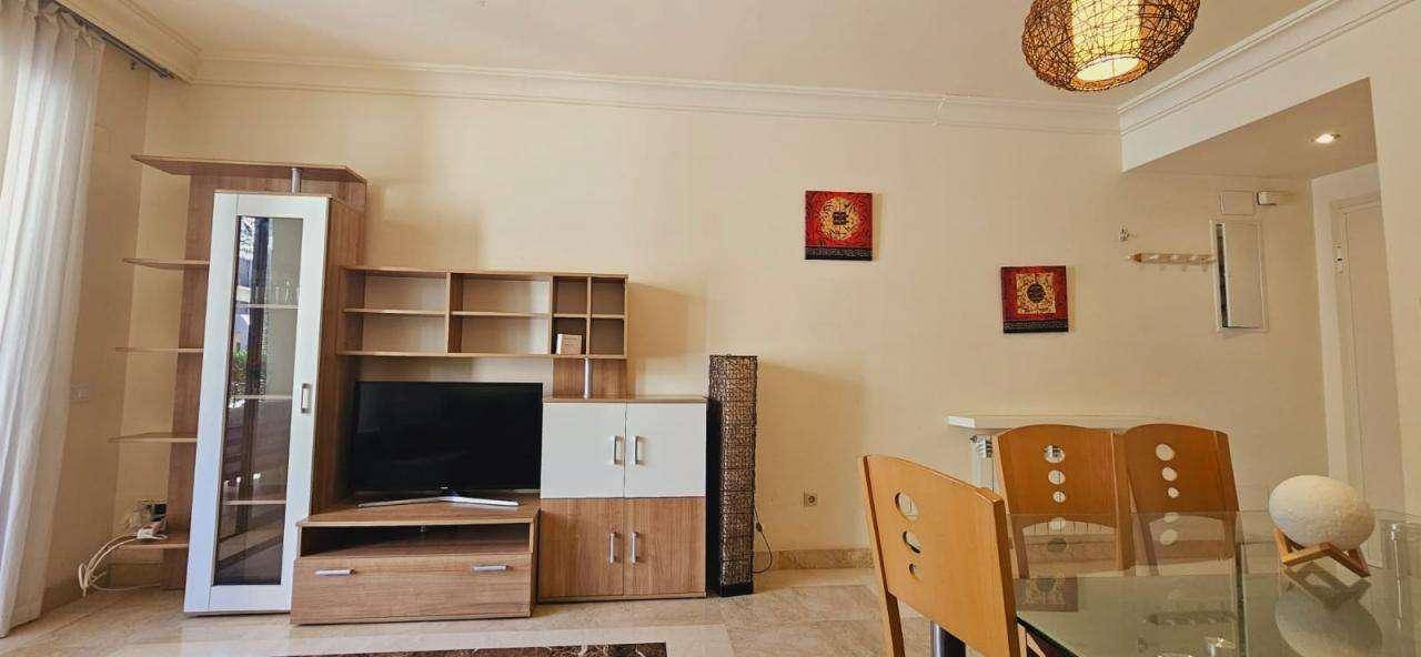 Wohnbereich mit TV-Möbeln, dekorativen Elementen und Blick auf den Essbereich.