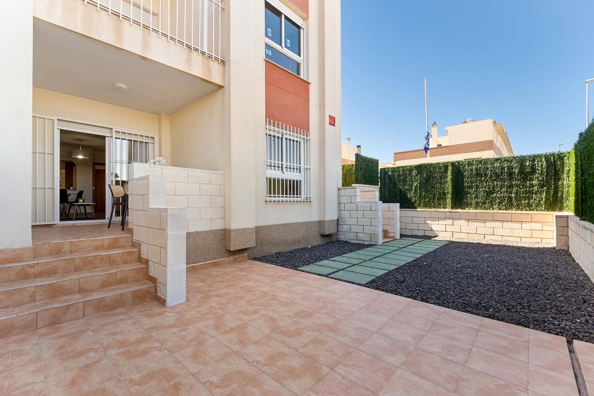 Gemütliche Terrasse mit Fliesenboden, Kiesbeet und Zugang zum Innenbereich des Apartments.