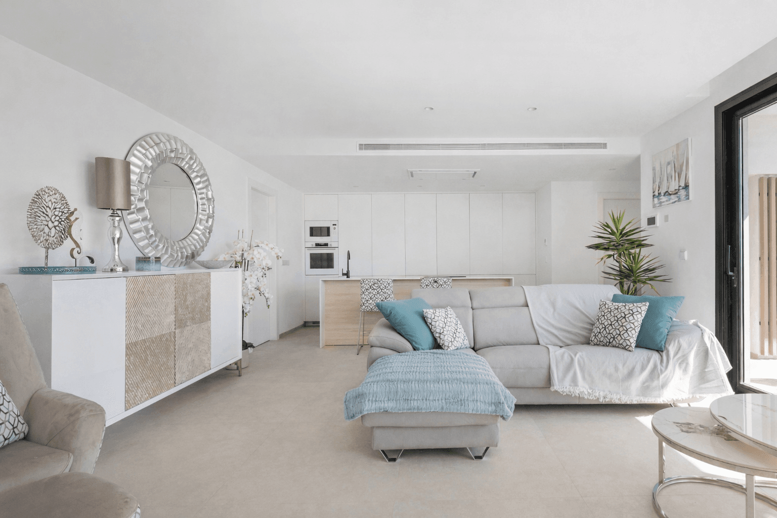 Offener Wohnbereich mit integrierter Küche, bequemer Couch und moderner Dekoration.