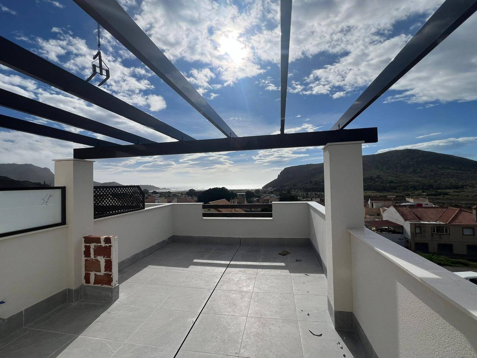 Helle Dachterrasse mit Pergola und beeindruckendem Ausblick auf Meer und Berge.