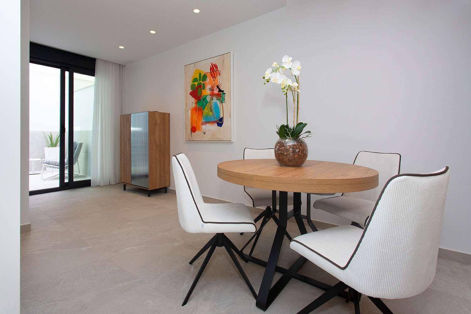 Stilvoller Essbereich mit rundem Holztisch, modernen Stühlen und Kunst an der Wand, sehr einladend.