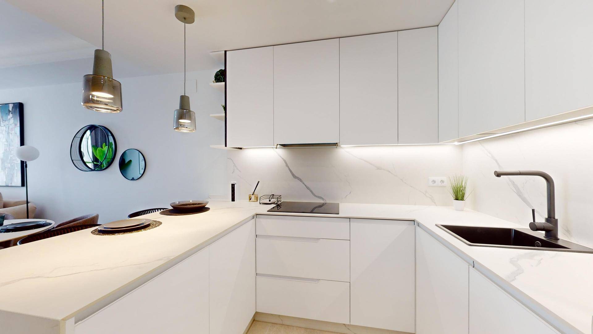 Helle moderne Küche mit weißer Arbeitsplatte, schwarzem Spülbecken und Induktionskochfeld.