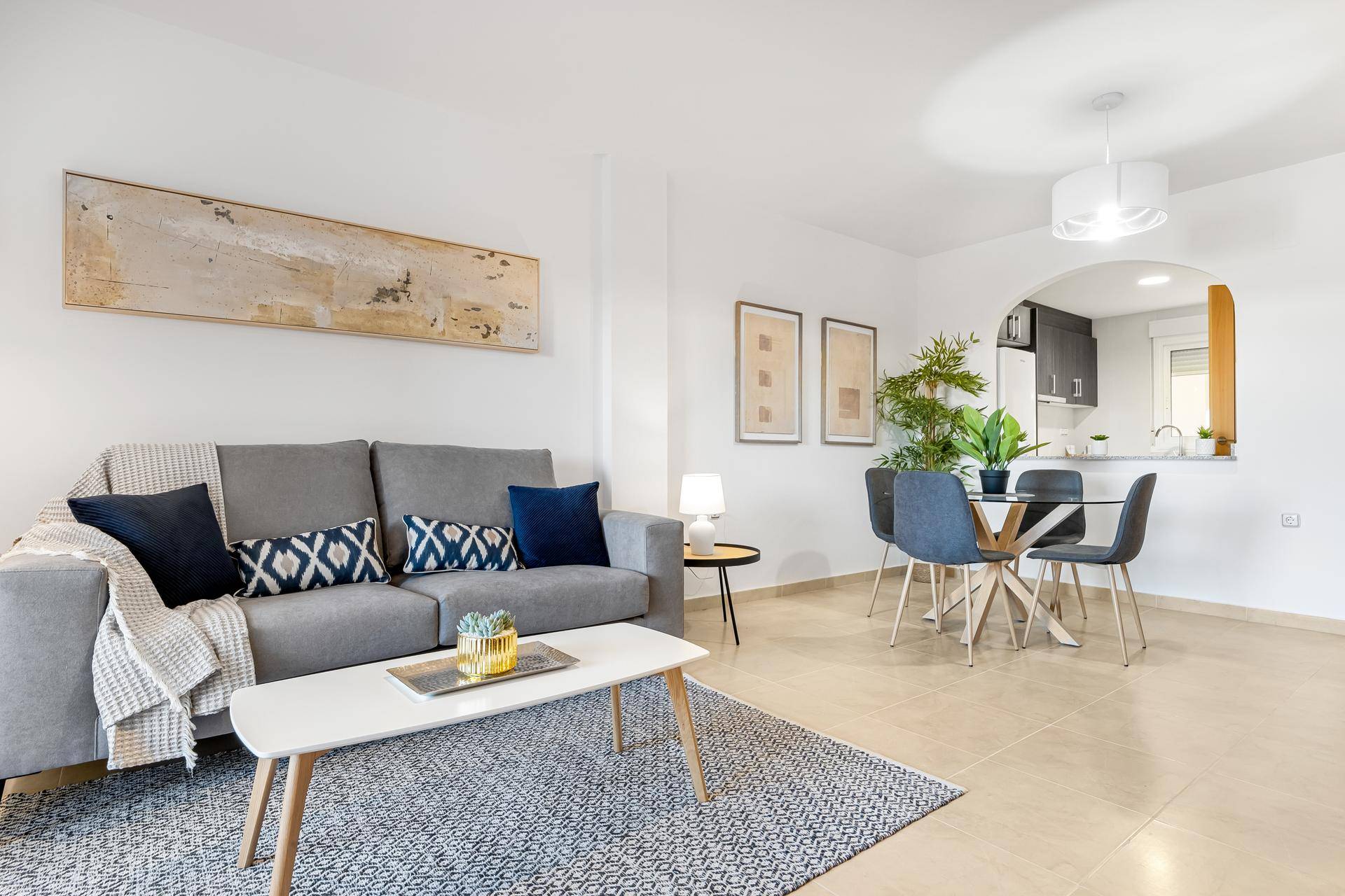 Offener Wohn- und Essbereich mit modernem Sofa, Esstisch und Blick zur Küche.