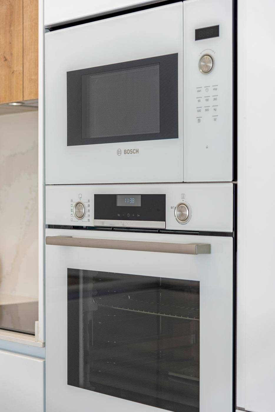 Eingebaute Küchengeräte von Bosch, darunter ein Backofen und eine Mikrowelle, in einer modernen Küche.
