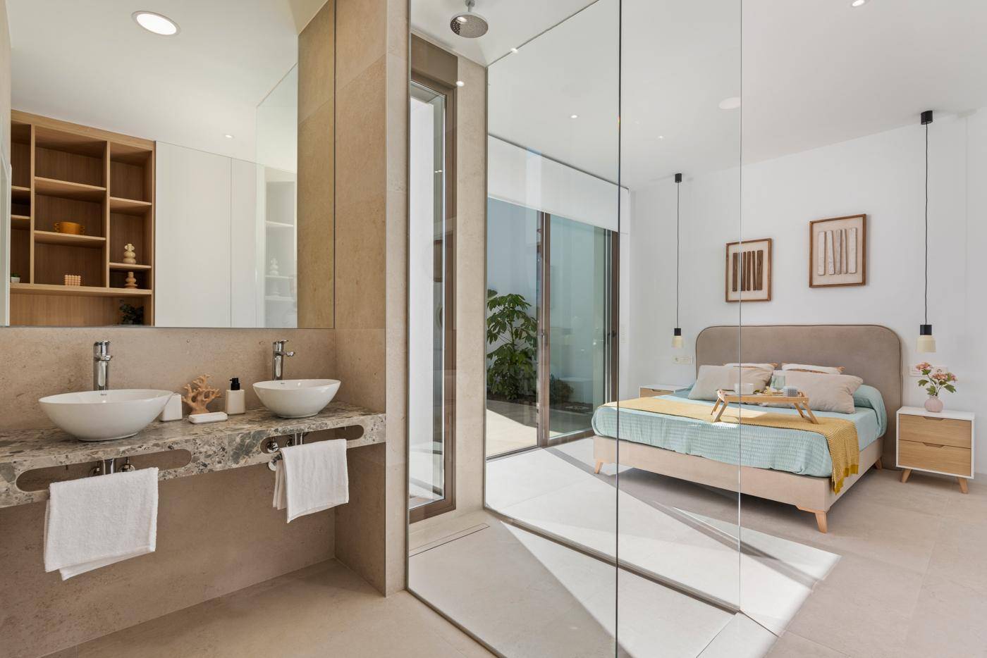 Modernes Schlafzimmer mit offenem Badbereich, Doppelwaschbecken und Glasdusche.