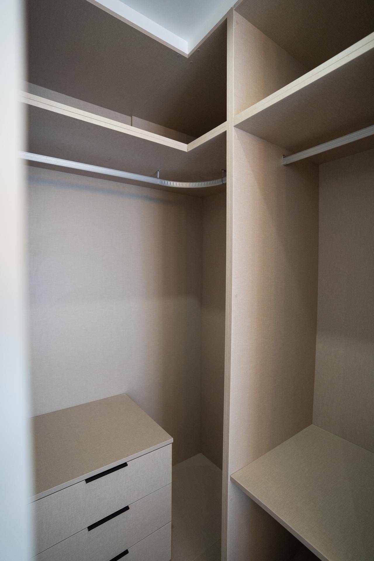 Begehbarer Kleiderschrank mit Regalen und Schubladen für optimale Organisation.
