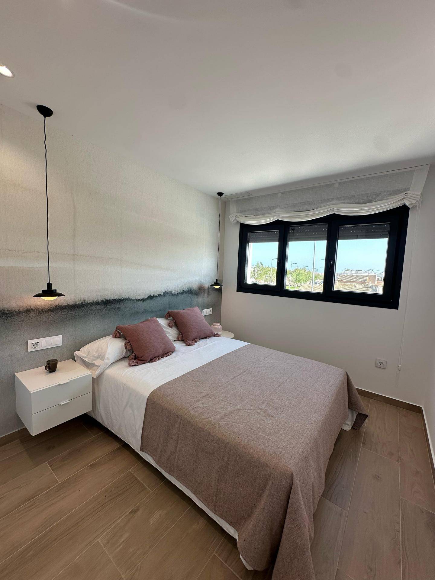 Komfortables Schlafzimmer mit Doppelbett, Nachttischen und Fenster für natürliches Licht.