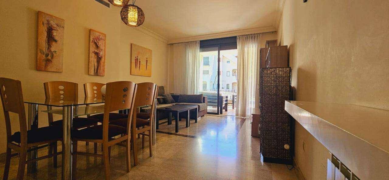 Geräumiger Wohn-Essbereich mit Fliesenboden, Esstisch und Zugang zum Balkon.