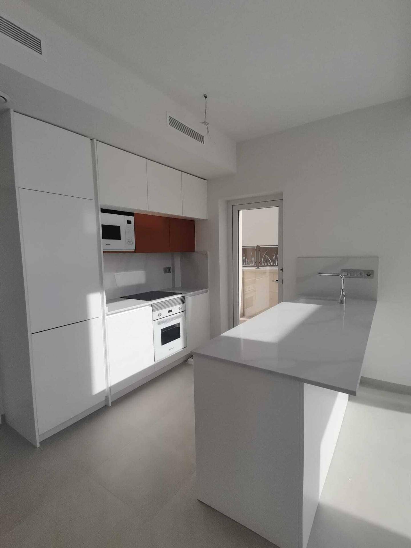 Moderne Einbauküche mit weißen Schränken, Kochfeld und Backofen, bereit zur Nutzung.