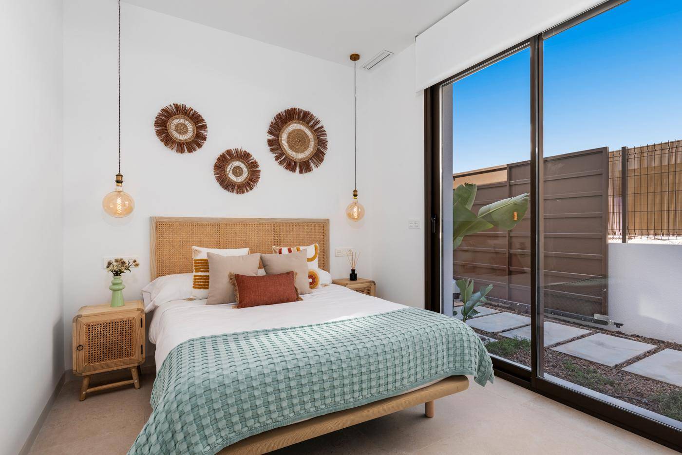 Helles Schlafzimmer mit großen Fenstern zum Innenhof und stilvoller, moderner Dekoration.