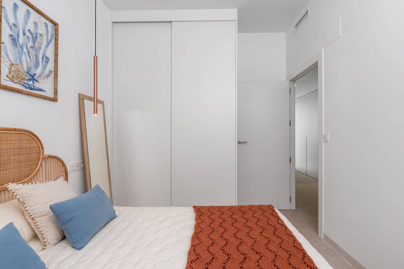 Schlafzimmer mit Einbauschränken und stilvoller Einrichtung, die eine gemütliche Atmosphäre schafft.