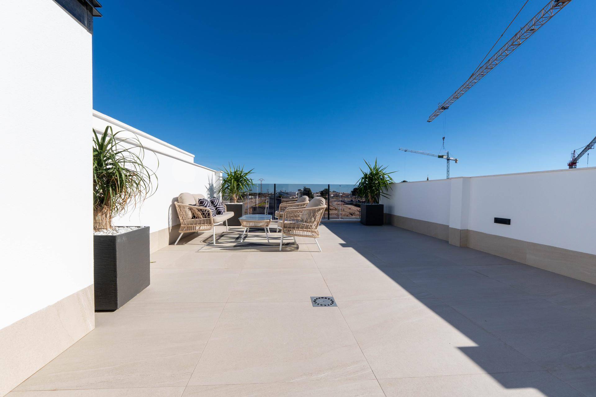 Große Dachterrasse mit Lounge-Möbeln, Pflanzen und weitem Blick auf die Umgebung.