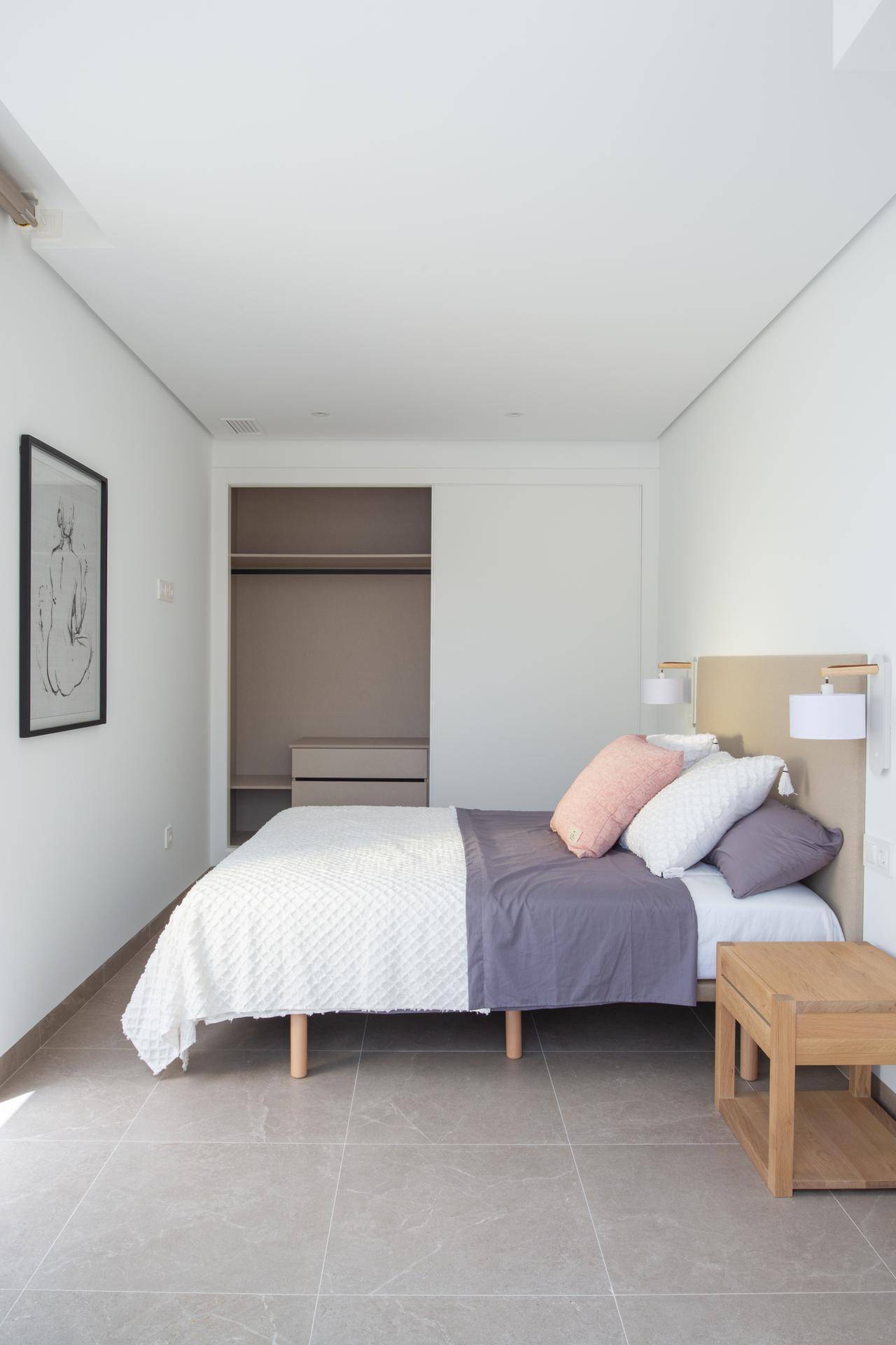 Helles Schlafzimmer mit Doppelbett, Nachttisch und praktischem Einbauschrank mit Schiebetüren.