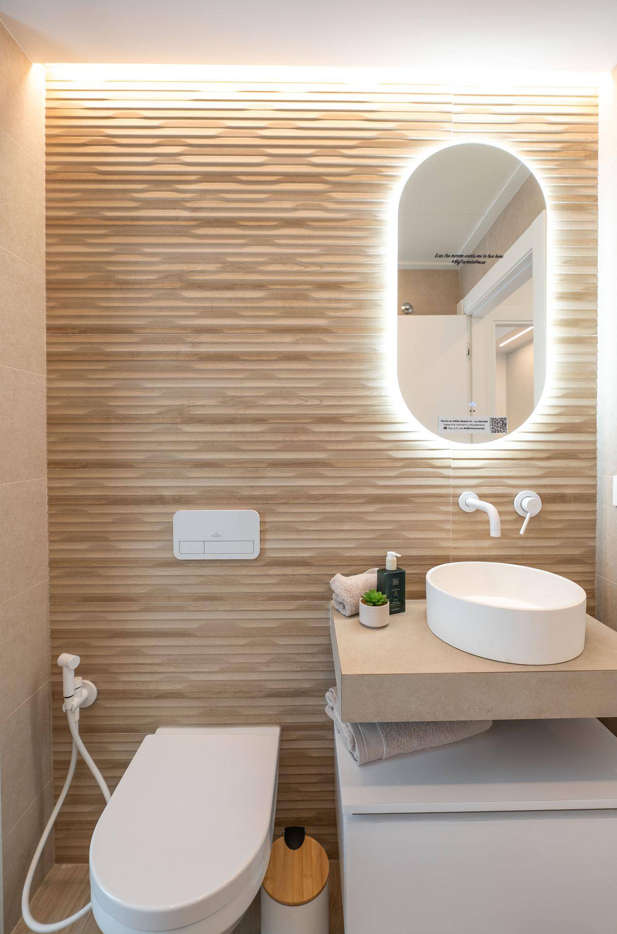 Modernes Badezimmer mit begehbarer Dusche, stilvollen Fliesen und beleuchtetem Spiegel.