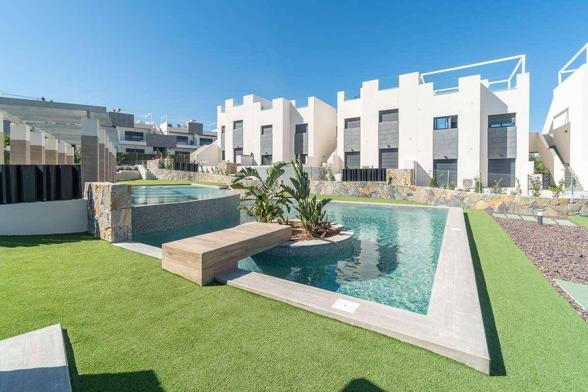 Moderne Wohngebäude umgeben von einer weitläufigen Poollandschaft mit integrierter Sitzbank.